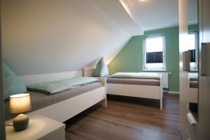 ein kleines Zimmer mit 2 Betten und einem Fenster in der Unterkunft Ferienwohnung Ravensberg Dachgeschoss in Bad Sachsa
