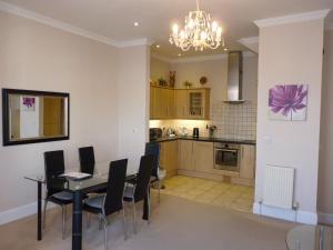 eine Küche und ein Esszimmer mit einem Tisch und Stühlen in der Unterkunft Cavendish apartment - central and spacious in Eastbourne