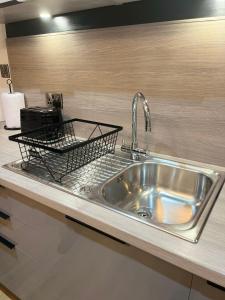 a kitchen sink with a basket on top of it at Perfect 1 Bed Apartment - Central with Parking, WiFi, TV, Desk in Peterborough