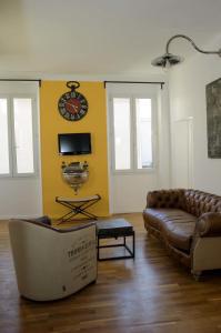 a living room with a couch and a clock on the wall at Appartement Cannes rue Marceau in Cannes