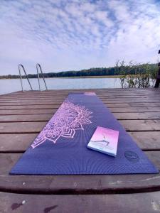 książkę siedzącą na matze do jogi na doku w obiekcie Charszówka w mieście Kobrzyniec Stary