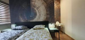 a bedroom with two beds and a painting on the wall at City Centre Apartment in Rēzekne