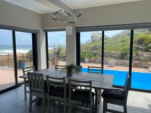 a dining room with a table and chairs and a view of the ocean at Coastal Haven in Scarborough