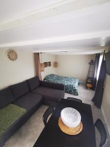 uma sala de estar com um sofá e uma mesa em Logement chaleureux avec parking gratuit em Oyré