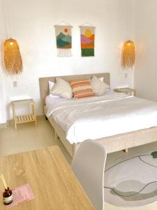 カントーにあるLASAOMA HOMESTAYのベッドルーム1室(壁に絵画2点が飾られたベッド1台付)