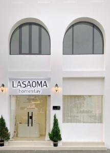 um armazém em frente a um edifício branco com homogeneidade lassoma em LASAOMA HOMESTAY em Can Tho