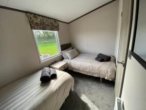 a small room with two beds and a window at Riverwood Lodge in Porth