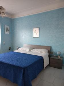 La Casa della Nonna Francesca في San Ferdinando di Puglia: غرفة نوم زرقاء مع سرير بجدار ازرق