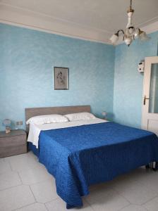 een blauwe slaapkamer met een bed met een blauwe muur bij La Casa della Nonna Francesca in San Ferdinando di Puglia