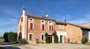 un edificio de ladrillo con persianas rojas. en Casa Matilde, en San Benedetto Po