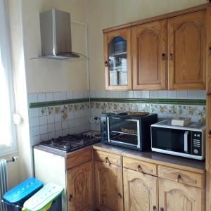 a kitchen with a microwave oven and a stove at Chambre meublée au cœur de ville - chez l'habitant in Le Creusot