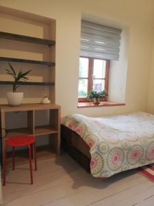 een slaapkamer met een bed, een bureau en een raam bij Vilnius Collegium Apartment in Vilnius