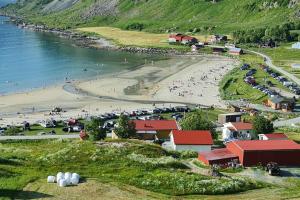 Ein Strand mit einem Haufen Leute am Strand in der Unterkunft Arctic Lodge Tromvik with jacuzzi in Tromsø