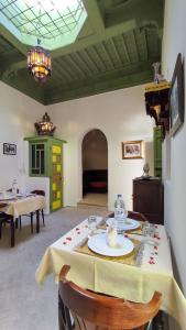 a dining room with a table and chairs and a room at RIAD DAR En-Nawat in Marrakesh