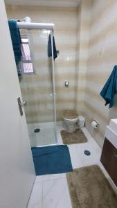 a bathroom with a shower with a toilet in it at SOL & MAR I com VARANDA - 1 dormitório - Canto do FORTE - 300 m da Praia e 20m da Avenida dos Barzinhos - ESTACIONAMENTO gratuito e WI Fi 300mbytes com TV a cabo - ap113 in Praia Grande
