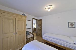- une chambre avec deux lits et une armoire dans l'établissement Chesa Centrum - Celerina, à Celerina