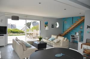 een woonkamer met een bank en een tafel bij La Magnifique Villa à 500m de la plage in Plozévet