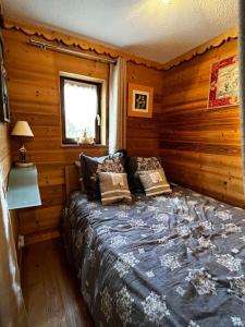 a bedroom with a bed in a wooden cabin at Appartement la Clusaz avec terrasse sur les pistes de ski in Manigod