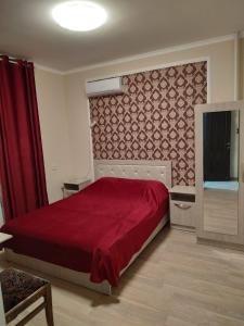 Schlafzimmer mit einem Bett mit einer roten Tagesdecke in der Unterkunft Отель Жылдыз in Jalal-Abad