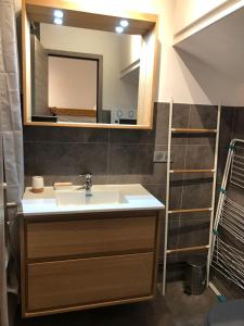 a bathroom with a sink and a mirror at charmant studio à la Rosière in Montvalezan