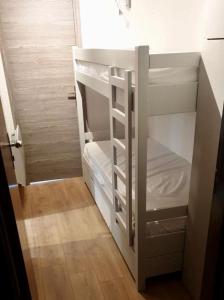 - un lit superposé blanc dans une petite chambre dans l'établissement charmant studio à la Rosière, à Montvalezan
