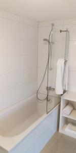 a white bathroom with a shower and a tub at SLEEP WELL Apartments, FEWO Falkenburg in Detmold