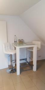 una silla y un escritorio blancos en una habitación blanca en SLEEP WELL Apartments, FEWO Falkenburg, en Detmold