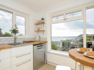 a kitchen with a table and a large window at 3 Meldrum Close in Dawlish