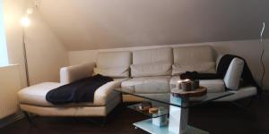sala de estar con sofá blanco y mesa de cristal en SLEEP WELL Apartments, FEWO Falkenburg, en Detmold