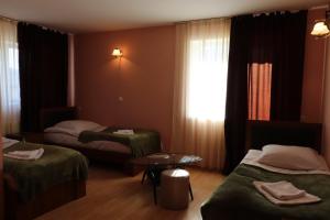 グダウリにあるGio Hotelのベッド2台、テーブル、窓が備わる客室です。