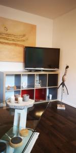 a living room with a tv and a glass table at SLEEP WELL Apartments, FEWO Falkenburg in Detmold