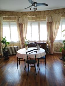 comedor con mesa, sillas y ventanas en Petite chambre meublée au cœur de ville - chez l'habitant, en Le Creusot