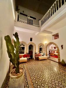 una sala de estar con una planta en un jarrón en Riad De La Mer, en Essaouira