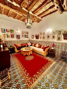 sala de estar con sofá y alfombra roja en Riad De La Mer, en Essaouira