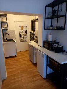 a kitchen with a white counter and a wooden floor at City center, peaceful, with free parking in Varaždin