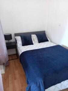 a bed in a bedroom with a blue blanket on it at City center, peaceful, with free parking in Varaždin