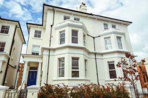 una casa blanca con una puerta azul en Cavendish apartment - central and spacious, en Eastbourne