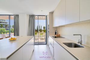 a kitchen with white cabinets and a counter top at weforyou Las Nereidas de Los Álamos 3 bedrooms and PARKING in Torremolinos