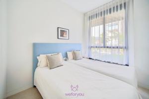 Cama blanca en habitación con ventana en weforyou Las Nereidas de Los Álamos 3 bedrooms and PARKING, en Torremolinos