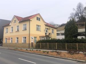 un edificio amarillo al lado de una calle en Penzion Agape, en Luhačovice