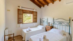 a bedroom with two beds and a window at Casa Guajar Monda by Ruralidays in Monda +30 photos