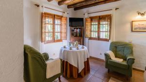 ein Wohnzimmer mit einem Tisch und 2 Stühlen in der Unterkunft Casa Guajar Monda by Ruralidays in Monda