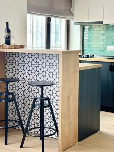 a kitchen with two bar stools and a patterned wall at City Center View Studio Apartment 1 in Timişoara +16 photos