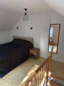 a bedroom with a bed and a mirror and a staircase at DEA's Apartment in Mavrovo