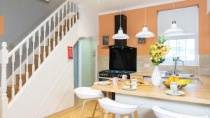 a kitchen with a wooden table and white chairs at Air Host and Stay - Daisy House - Large 3 bedroom sleeps 7 10 minutes from city centre in Liverpool