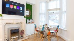 a living room with a fireplace and a table with chairs at Air Host and Stay - Daisy House - Large 3 bedroom sleeps 7 10 minutes from city centre in Liverpool