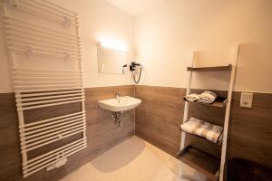 W łazience znajduje się umywalka i prysznic. w obiekcie HeimatHerz Hotel Garni w mieście Herdecke