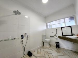 a bathroom with a toilet and a sink and a shower at Avondrust Guest House in Klaarstroom
