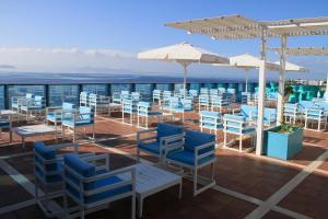 a patio with blue chairs and tables and umbrellas at Sandos Papagayo in Playa Blanca