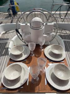 a table with plates and wine glasses on a boat at Sea Bloom - Sleep & Sail in Tejo in Lisbon